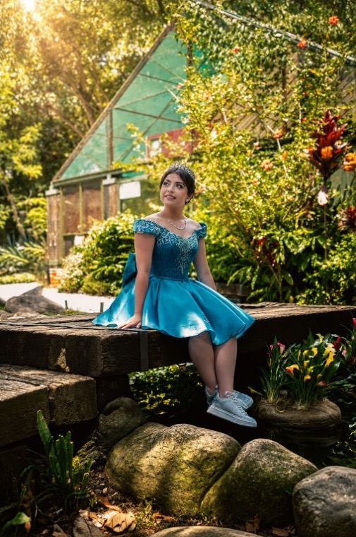Sofí sentada en un puente de madera en el jardín